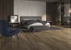 Sypialnia z garderobą w ciemnym drewnie i wielkoformatowym betonie