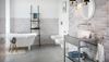 Aranżacja łazienki z szarymi płytkami i patchworkową ścianą