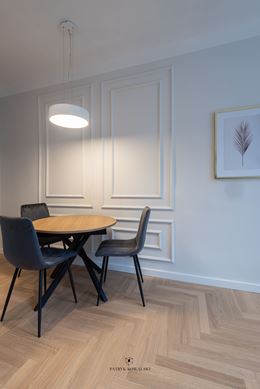 Jadalnia z okrągłym stołem na tle sztukaterii