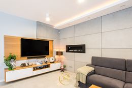 Salon z kominkiem i betonową ścianą