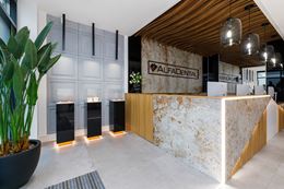 Recepcja kliniki stomatologicznej z ladą w kamieniu i drewnie