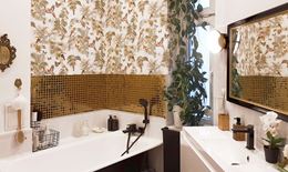 Łazienka ze złotą mozaiką i tapetą nad wanną