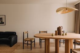Minimalistyczna jadalnia z dużym, asymetrycznym stołem z drewna