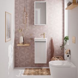 Biała toaleta z różową ścianą z geometrycznym wzorem