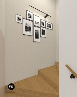 Asymetryczna galeria zdjęć w czarnych ramkach na ścianie klatki schodowej