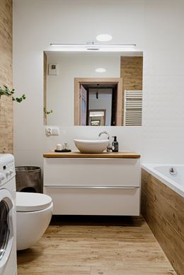 Łazienka z wanną w bieli i drewnie