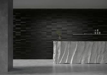 Czarne cegiełki i szary beton w aranżacji przestrzeni recepcji