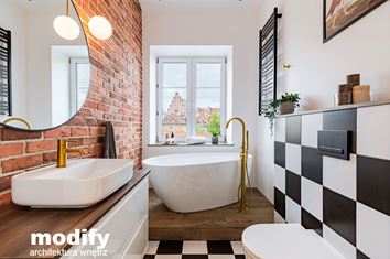Czerwona cegła i biało-czarne płytki w łazience