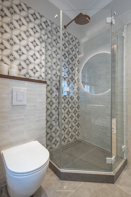 Łazienka z szarymi cegiełkami i i płytkami z geometrycznym wzorem