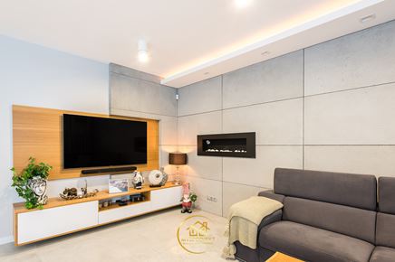 Salon z kominkiem i betonową ścianą