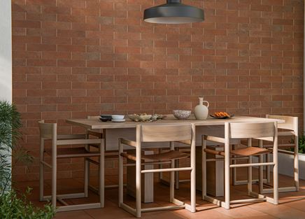 Drewniany stół na tarasie w brązowych cegiełkach