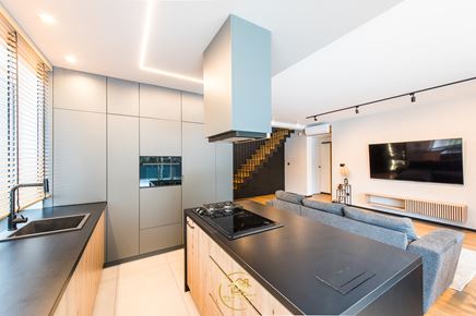 Kuchnia z wyspą otwarta na jasny, loftowy salon