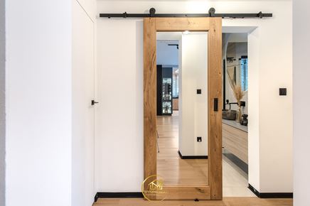 Przedpokój z przesuwnymi drzwiami do łazienki z lustrem