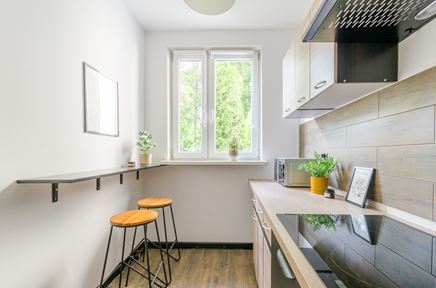 Wąska, jednorzędowa kuchnia z blatem barowym na ścianie