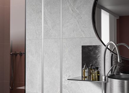 Ściana w łazience w szarych kamieniach i srebrnych listwach