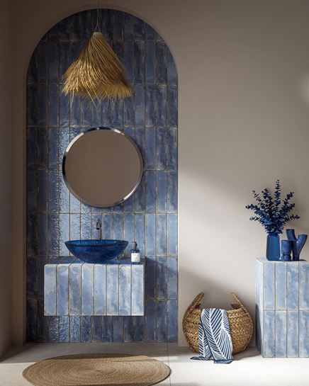 Cegiełkowe wykończenie łazienki z niebieską umywalką