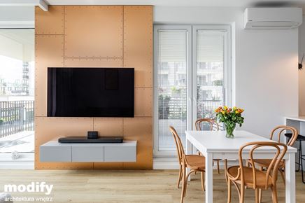 Jadalnia w salonie z miedzianą ścianą RTV