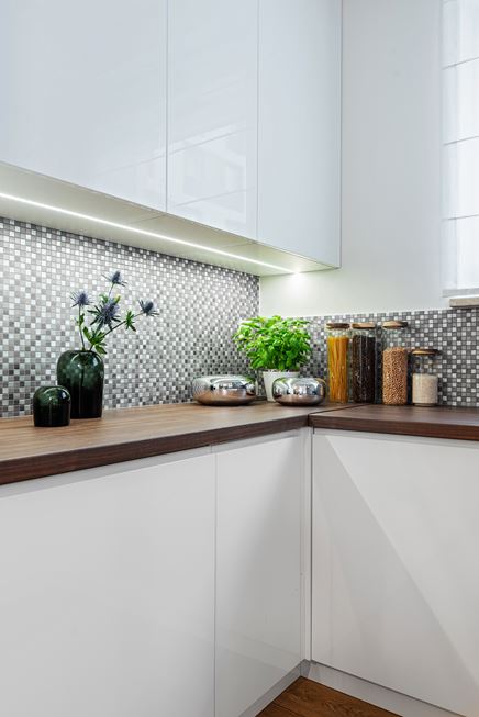 Biała zabudowa kuchenna z metalicznym akcentem