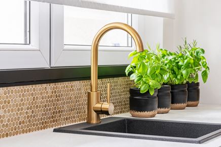 Jasna kuchnia z oknem ze złotymi akcentami