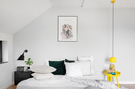 Minimalistyczna sypialnia z żółtą lampką
