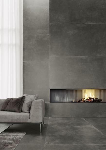 Salon z kominkiem w grafitowych płytach z motywem betonu