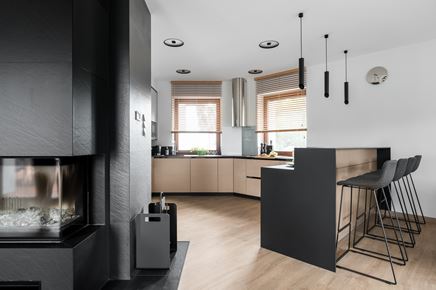 Kuchnia z wysokim, czarnym barem śniadaniowym