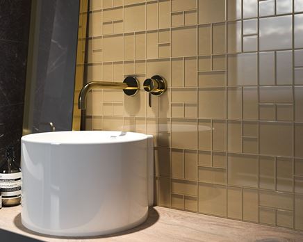 Złota mozaika na ścianie w łazience