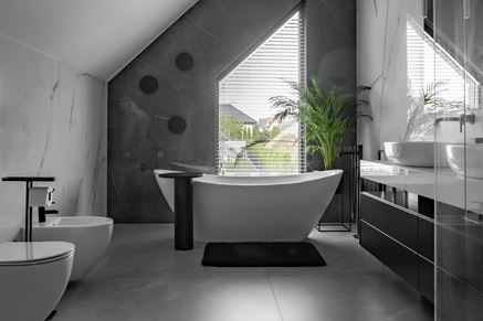 Duży, biało-szary salon kąpielowy z wolnostojącą wanną