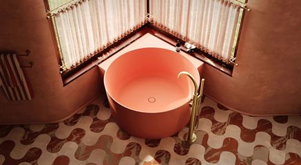 Różowa wanna w terakotowej łazience