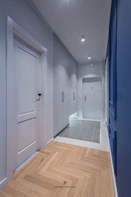 Aranżacja korytarza z szarymi szafami z podcięciem na buty