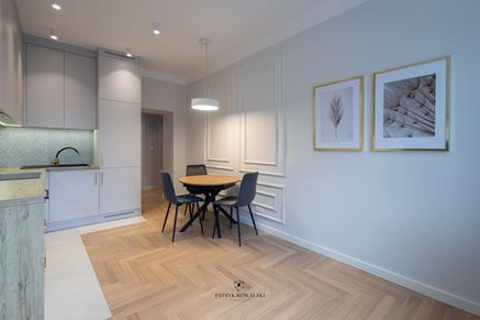 Kuchnia z jadalnią z klasycznymi akcentami sztukaterii i jodełki