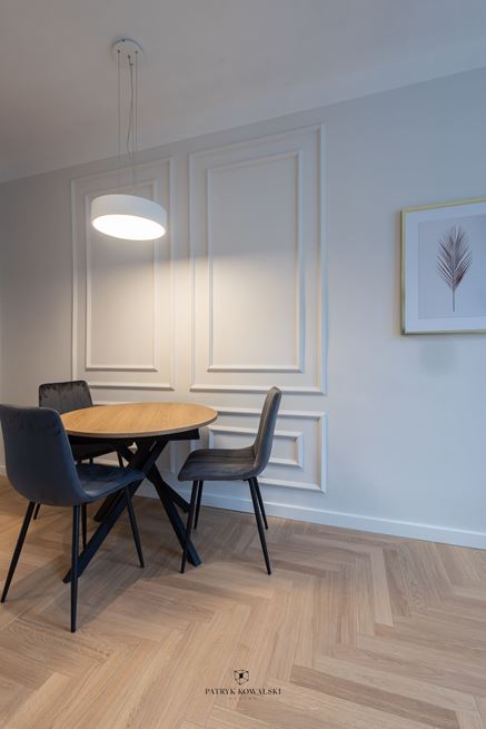 Jadalnia z okrągłym stołem na tle sztukaterii