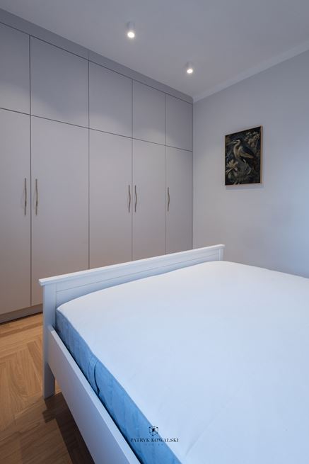 Ściana z szarymi szafami w sypialni