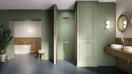 Zielona łazienka z kabiną wnękową z miedzianymi profilami
