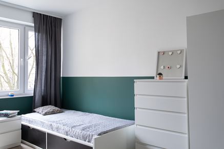 Sypialnia z zieloną lamperią i białymi meblami