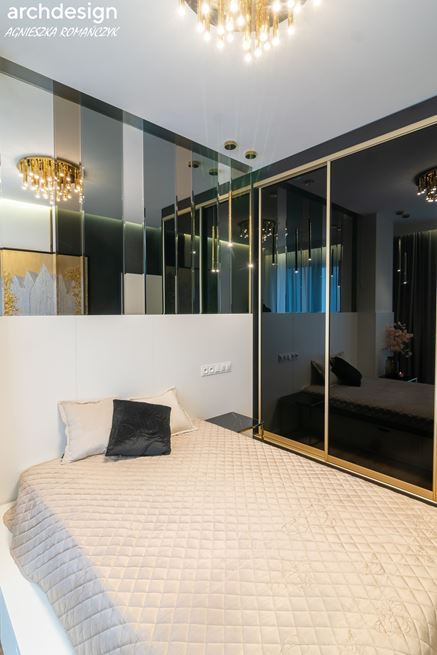 Detale sypialni z lustrzanymi panelami za łóżkiem