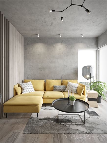 Strefa dzienna w betonie z żółtą sofą