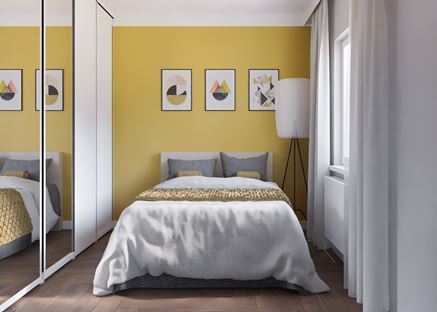 Nieduża sypialnia z żółtą ścianą
