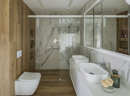 Duży prysznic w eleganckiej łazience z marmurem i drewnem