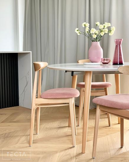 Jadalnia wyposażona w stół z białym blatem i krzesła z różowymi siedziskami