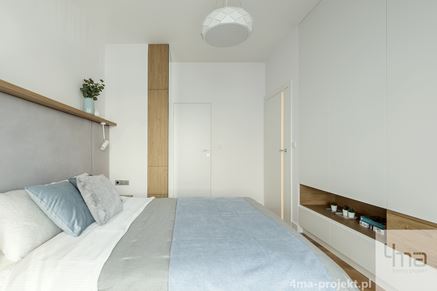 Sypialnia z białymi, minimalistycznymi zabudowani