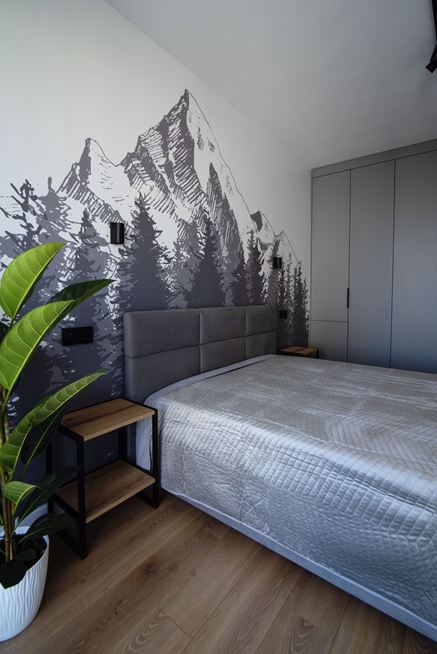 Sypialnia z górską tapetą za łóżkiem