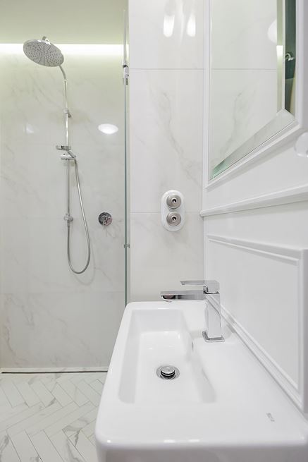 Biała łazienka z kabiną wnękową i marmurową jodełką