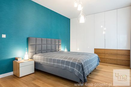 Prosto i nowocześnie urządzona sypialnia z niebieską ścianą