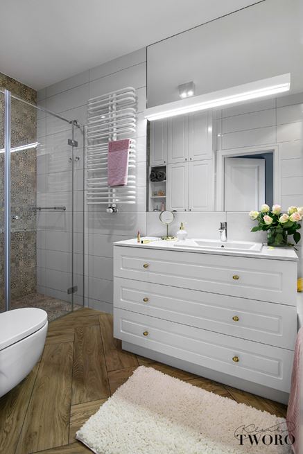 Biała łazienka z patchworkiem i drewnianą jodełką