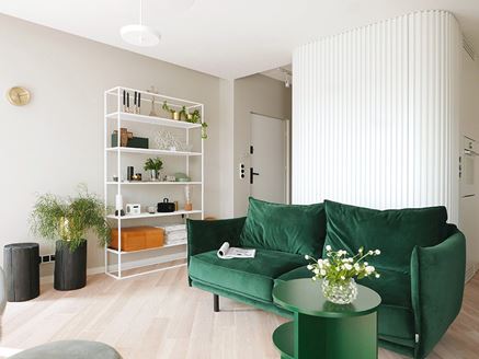 Zielona kanapa w aranżacji minimalistycznego salonu