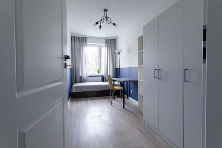 Sypialnia z niebieską lamperią i białymi szafami