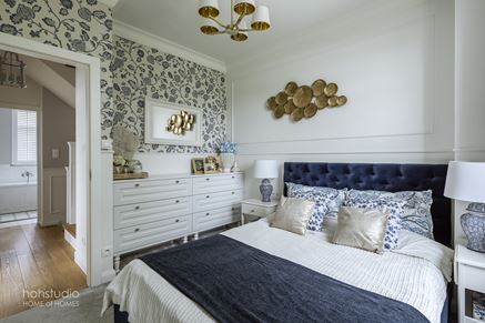 Biało-granatowa sypialnia z kwiatową tapetą