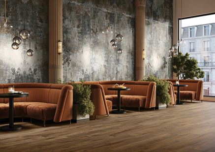 Surowy beton i drewniana podłoga w aranżacji przestrzeni restauracyjnej