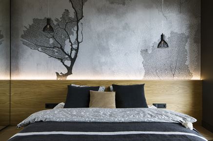 Sypialnia z szarą, graficzną tapetą za łóżkiem